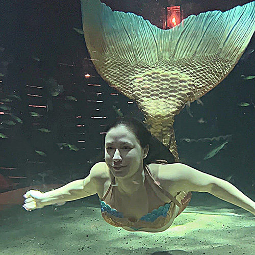 A "mermaid" smiles beneath the water.
