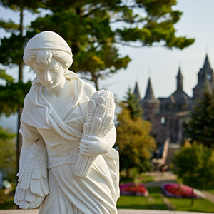 A statue with a castle in the background.