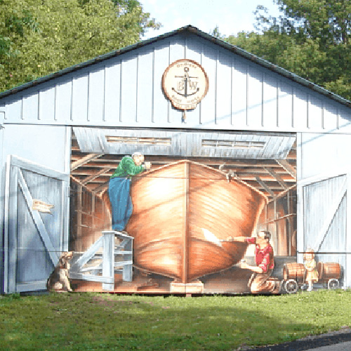 A historic building with a mural painted on the front of an old boat.