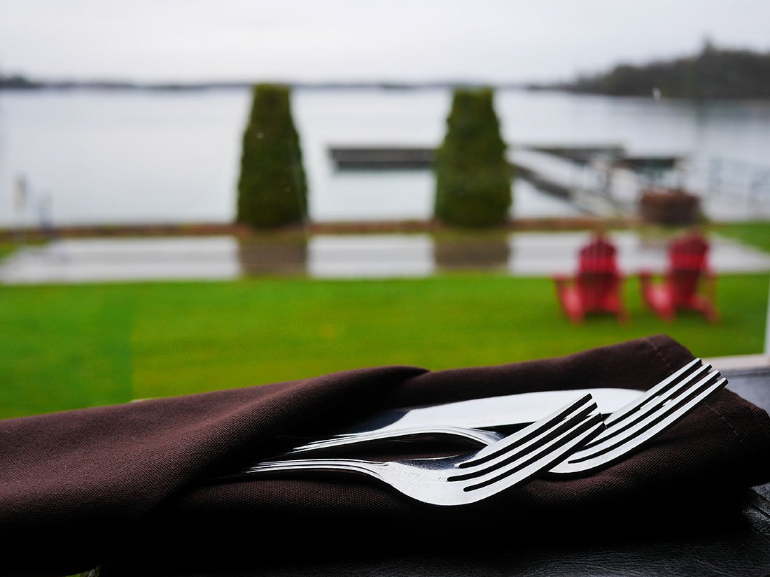 Silverware tucked into a black napkin on a patio table.