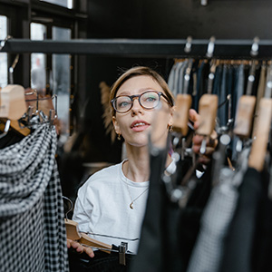 A person sorting through a rack of clothing.