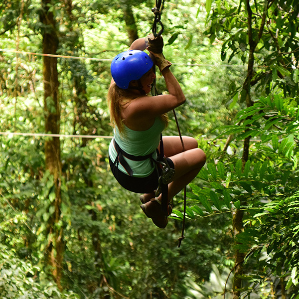 A person wearing a blue helmet treetop trekking in the 1000 Islands.